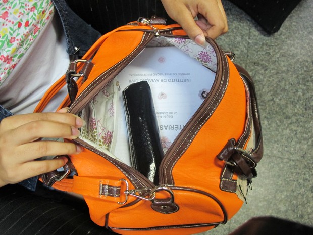 Garota mostra que na bolsa só havia livros da escola (Foto: Anna Gabriela Ribeiro/G1)