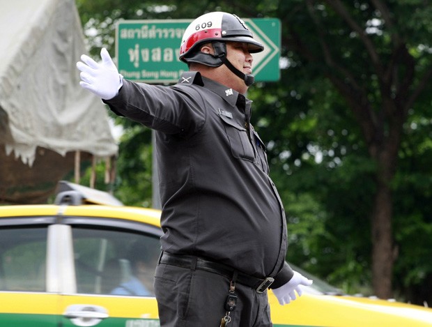 O policial de trânsito Wanchat Wongnothong é visto trabalhando em rua de Bangcoc. Governo iniciou programa para oficiais perderem peso (Foto: Apichart Weerawong/AP) O policial de trânsito Wanchat Wongnothong é visto trabalhando em rua de Bangcoc. Governo iniciou programa para oficiais perderem peso (Foto: Apichart Weerawong/AP)