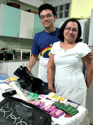 Antônia e seu filho mais novo mostram kit da mochila (Foto: Mônica Dias/G1 AM)