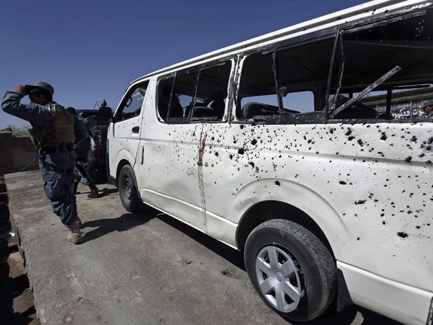 Policial afegão inspeciona veículo danificado em Cabul nesta terça (15) (Foto: Omar Sobhani/ Reuters)
