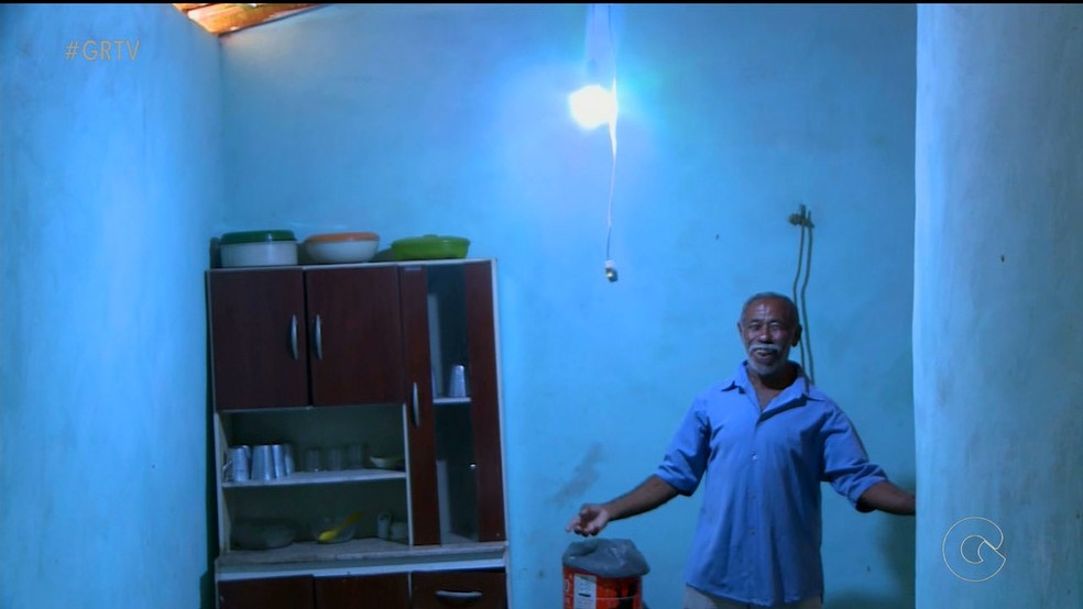 Seu Francisco alegre com lâmpada acesa em casa (Foto: Reprodução/TV Grande Rio)