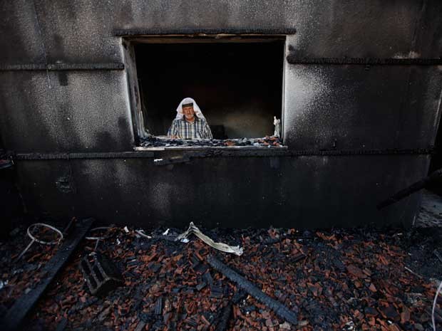 Palestino inspeciona casa após incêndio; bebê palestino morreu no local  (Foto: Majdi Mohammed / AP Photo)