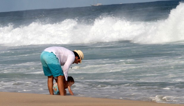 Marido de Letícia Birkheuer com o filho na praia (Foto: Wallace Barbosa / AgNews)