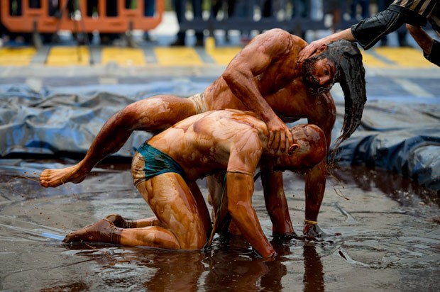 Competidores se enfrentam em piscina com molho (Foto: Oli Scarf/AFP)