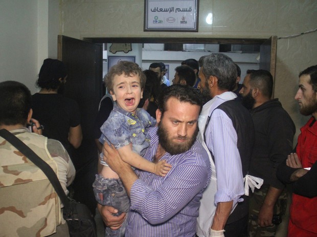 Sírio carrega criança em hospital após bombardeio russo em Idleb (Foto: Omar haj kadour/AFP)