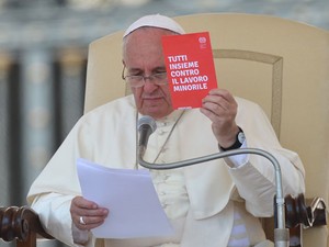O Papa Francisco mostra cartão no qual se lê ‘todos juntos contra o trabalho infantil’ durante audiência desta quarta-feira (11) na Praça São Pedro (Foto: Vincenzo Pinto/AFP)