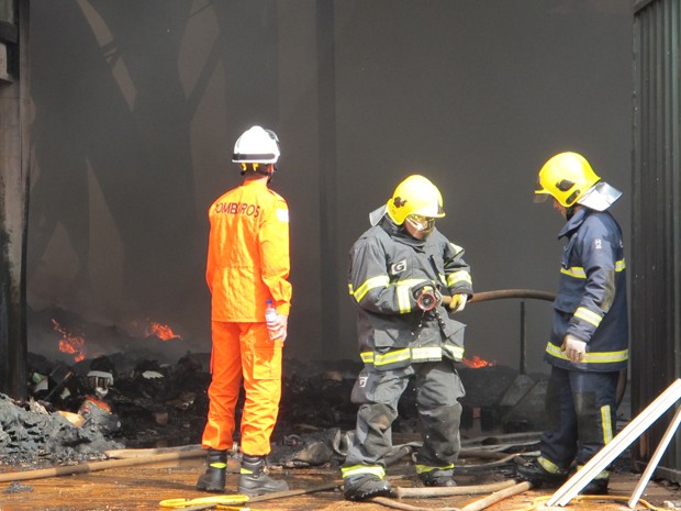 Bombeiros trabalham no combate a pequenas chamas no interior do galpão  (Foto: Káthia Mello/G1)