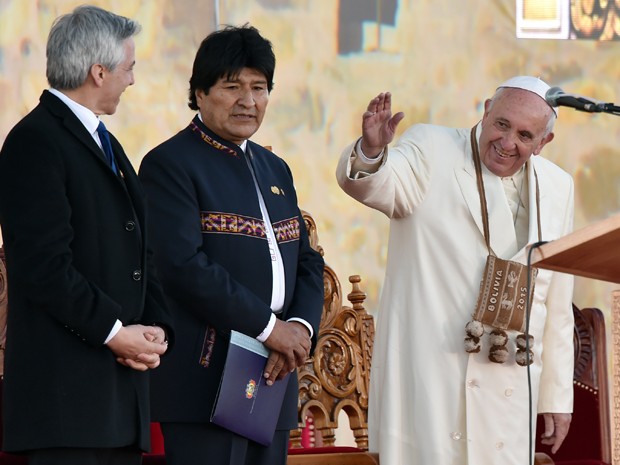 O Papa Francisco acena ao lado do presidente da Bolívia, Evo Morales, e do vice-presidente, Álvaro Garcia Linera, no aeroporto de El Alto, na quarta (8) (Foto: AFP Photo/Cris Bouroncle)
