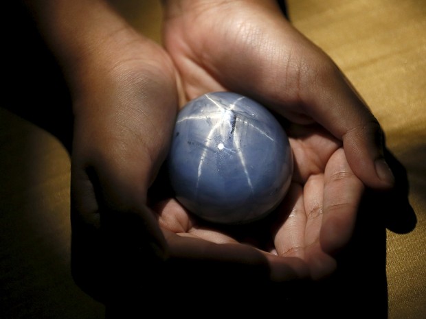 Dono da maior safira azul do mundo segura a pedra durante entrevista (Foto: Dinuka Liyanawatte / Reuters) Dono da maior safira azul do mundo segura a pedra durante entrevista (Foto: Dinuka Liyanawatte / Reuters)