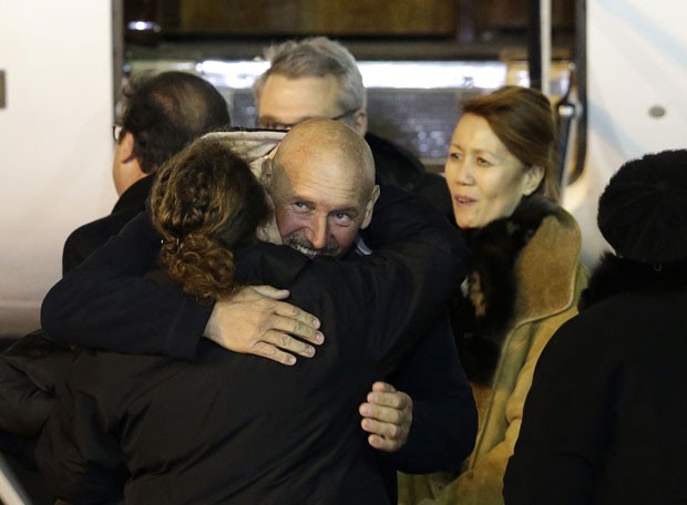 O ex-refém francês Serge Lazarevic é abraçado por familiares ao chegar a aeroporto militar perto de Paris nesta quarta-feira (10) (Foto: Philippe Wojazer/Reuters)