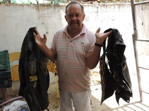 Clécio galvão, dono do imóvel mostra roupas que foram destruídas pelo fogo (Foto: Edivaldo Braga/Blog Braga)