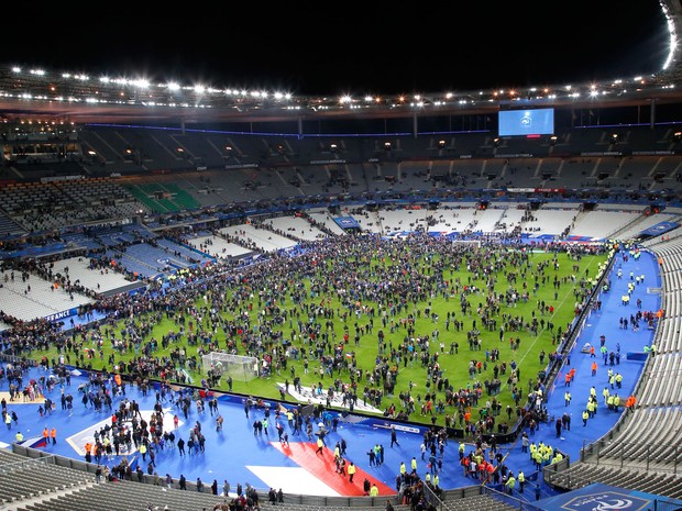 Público no campo do Stade de France após a série de ataques (Foto: Michel Euler/AP)