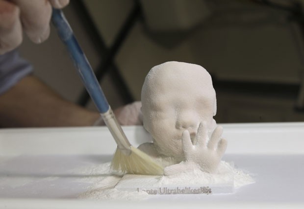 A reprodução do feto em 3D recebe retoques e pintura antes de ser entregue aos pais (Foto: Ints Kalnins/Reuters)