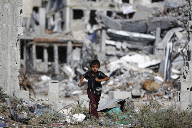 Criança é vista em frente a prédio destruído na cidade de Gaza nesta terça-feira (21) (Foto: Mohammed Abed/AFP)