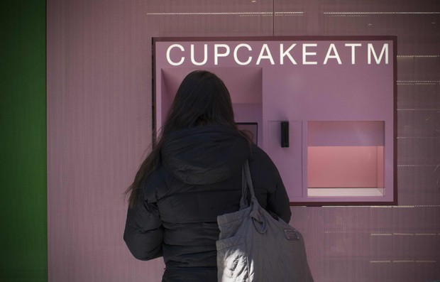 Mulher compra um cupcake em máquina de vendas automática na região do Upper East Side, em Manhattan, Nova York  (Foto: Reuters/Mike Segar)