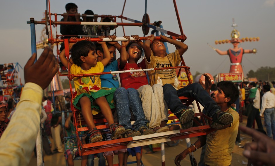 Crianças indianas brincam em parque de diversões durante celebrações da festa de Dussehra, em Nova Deli. A festa hindu comemota o triunfo do deus Rama sobre o demônio Ravana, marcando a vitória do bem sobre o mal
