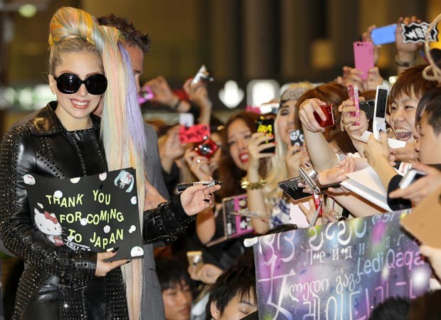 Lady Gaga saúda fãs ao chegar ao aeroporto Narita, em Tóquio, em 8 de maio (Foto: AFP)