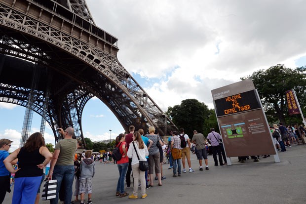 Turistas fazem fila para visitar a Torre Eiffel nesta sexta-feira (9) após ela reabrir (Foto: AFP)