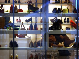 Mulher experimenta par de botas em uma loja no centro de Pequim (Foto: David Gray/Reuters)