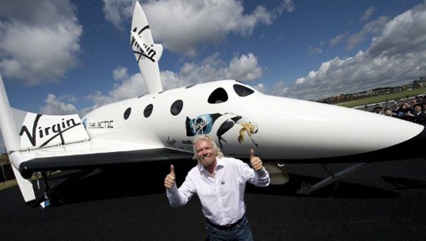 O bilionário inglês Richard Branson, posa em frente ao protótipo do LauncherOne, aeronave feita para realizar voos espaciais comerciais. (Foto: Adrian Dennis/AFP)