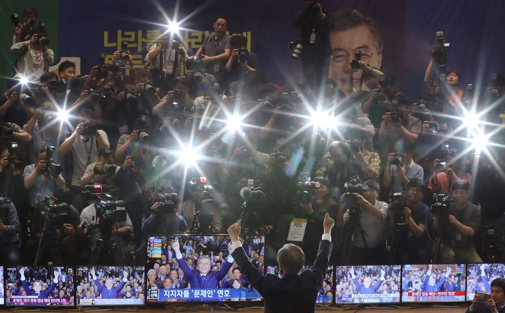 Moon Jae-in levanta os braços durante a transmissão dos resultados da eleição presidencial na Coreia do Sul  (Foto: Lee Jin-man/AP)