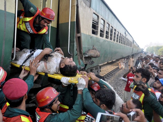 Ferido é retirado de trem que colidiu com outro trem no Paquistão (Foto: Khalid Chaudry / Reuters)
