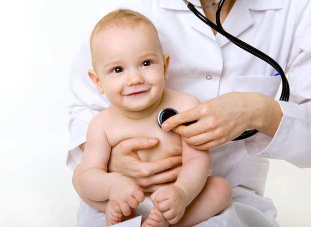 Bebê no colo do pediatra (Foto: Shutterstock)