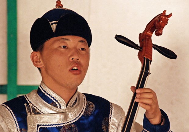 Um músico toca o violino Morin Khuur; fios do rabo de cavalo são usados para as duas cordas. O violino traz uma talha da cabeça equina no cabo  (Foto: Haroldo Castro/ÉPOCA)