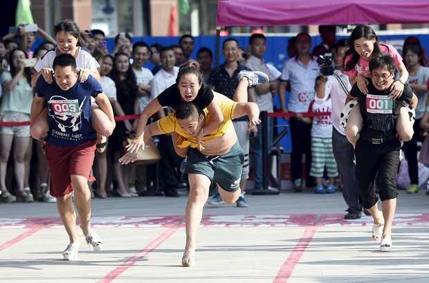 Por anel, chineses correram de salta alto carregando esposas nas costas (Foto: Reuters)