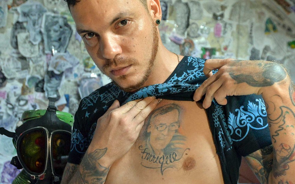 Juan José Herrera, que é tatuador, mostra uma tatuagem do rosto de seu pai (Foto: Luis Robayo / AFP Photo)