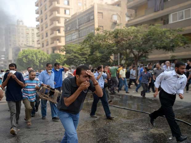Seguidores do presidente deposto correm da ação da polícia. (Foto: Khaled Desouki / AFP Photo)
