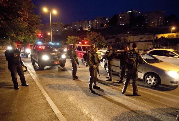 Policiais israelenses procuram por foguete que teria caído na região de Jerusalém nesta sexta-feira (16) (Foto: AP)