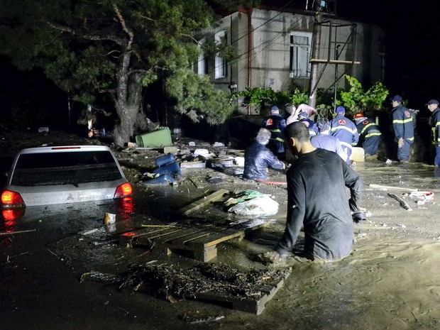 Moradores em uma rua inundada em Tbilisi (Foto: Irakli Gedenidze / Reuters)