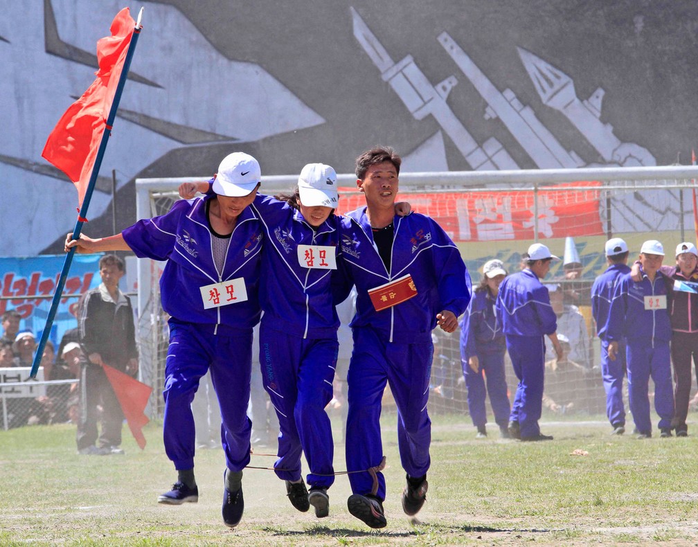 Com as pernas amarradas umas nas outras, homens participam de gingana em Pyongyang, na Coreia do Norte, para celebrar o Dia do Trabalhar nesta segunda-feira, dia 1º de maio de 2017 (Foto: Jon Chol Jin/AP)