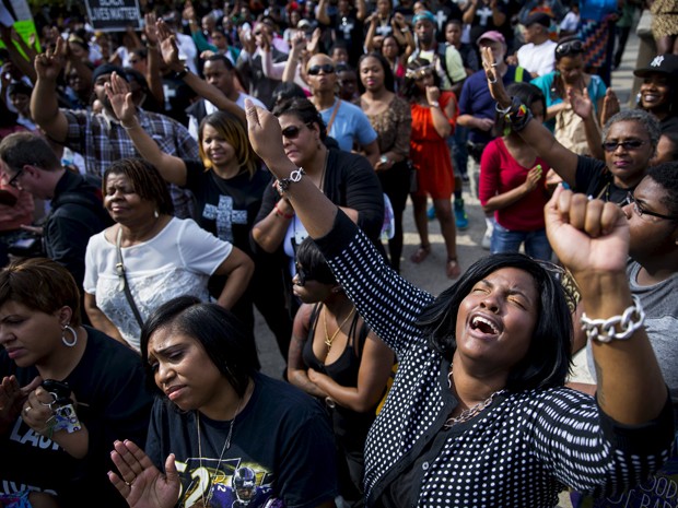Pessoas cantam e rezam durante evento organizado por líderes religiosos perto da prefeitura de Baltimore no domingo (3) (Foto: Reuters/Eric Thayer)