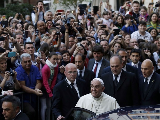 Seguranças tentam proteger o Papa Francisco da aproximação de fiéis na saída de igreja (Foto: Gregorio Borgia/AP)