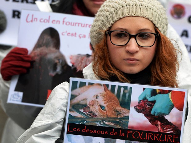 Manifestante carrega imagem de animais durante o ato (Foto: Pierre Andrieu/ AFP)