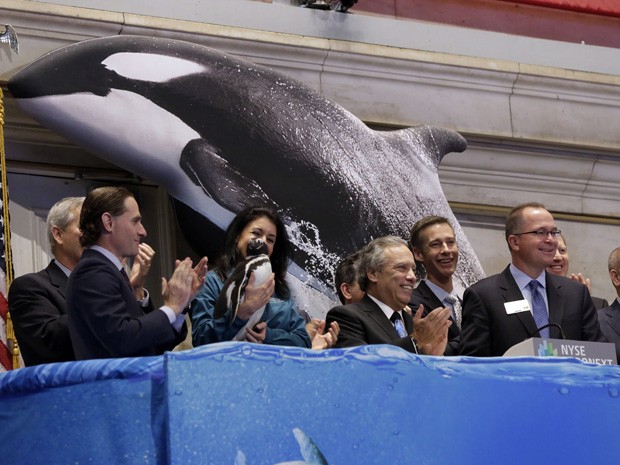 O presidente do Sea World, Jim Atchinson (o terceiro a partir da direita), toca o sinal que marca o início das negociações na bolsa de NY.  (Foto: Richard Drew/AP)
