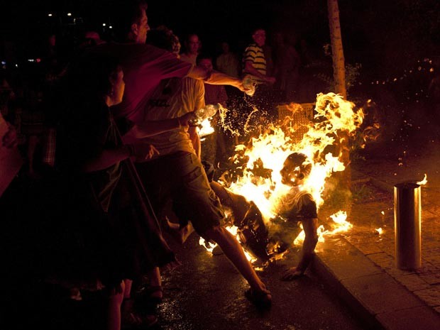 Pessoas tentam apagar o fogo do corpo de manifestante (Foto: Reuters/Ben Kelmer)