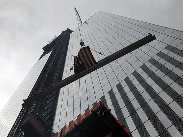 A última viga de aço é elevada ao topo do 4º prédio do novo World Trade Center (WTC), em Nova York. A torre, de 298 metros, será inaugurada no final de 2013. (Foto: Mark Lennihan / AP Photo)