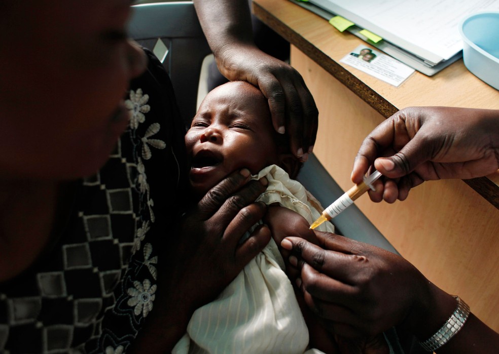   Foto de 209 mostra mãe segurando bebê que recebe vacina contra malária em teste inicial no Quênia  (Foto: AP Photo/Karel Prinsloo, File)
