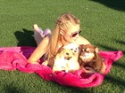 Paris Hilton relaxa sobre a grama com as suas três cachorrinhas