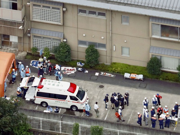 Ambulâncias e policiais são vistos em frente ao centro Tsukui Yamayuri-en, onde um homem atacou pacientes com uma faca na madrugada de terça (26), em Sagamihara, no Japão (Foto: Kyodo News via AP)