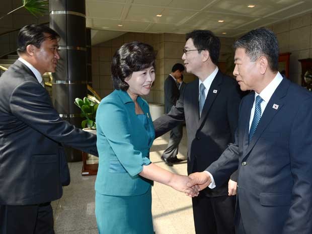 Chefe da delegação norte-coreana, Kim Song-hye, aperta a mão com os delegados sul-coreanos antes das negociações a nível de trabalho entre as Coreias neste domingo (9) (Foto: Ministério da Unificação sul-coreano/ HO/ AFP)