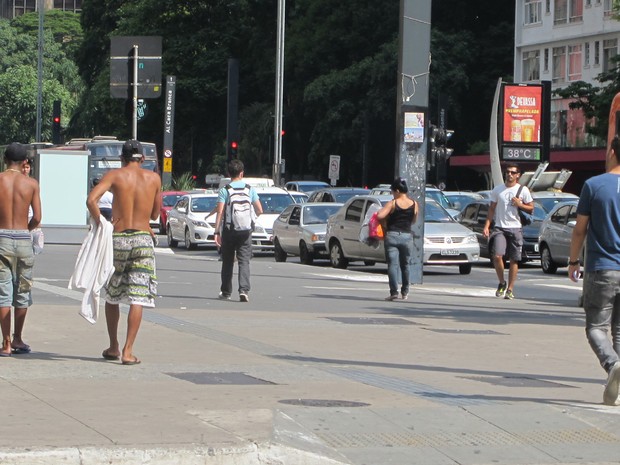 Jovens caminham sem camiseta na Avenida Paulista; termômetros de rua registram 38 graus. (Foto: Paulo Toledo Piza/G1)