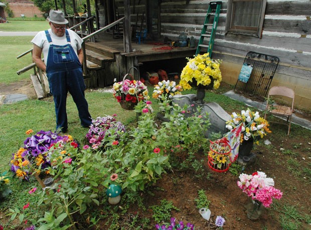 James Davis tenta manter a sepultura de sua esposa no jardim de sua casa. (Foto: Jay Reeves/AP)