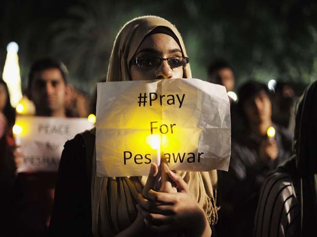 Paquistanesa segura placa com os dizeres 'Reze por Peshawar' durante homenagem em Sydney (Foto: REUTERS/Jason Reed)