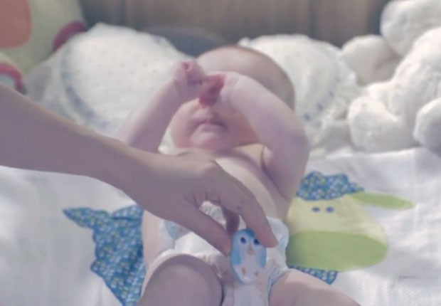 Em anúncio em vídeo, mãe coloca o TweetPee na fralda do bebê. Sensor identifica quando ele fez xixi e manda uma mensagem pelo Twitter para a mãe (Foto: Divulgação/Huggies)