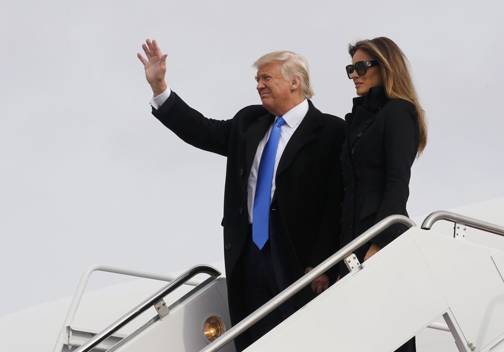 Donald Trump acena, ao lado da mulher, Melania, ao chegar a Washington na tarde de quinta (19), véspera de sua posse (Foto: Jonathan Herst/Reuters)