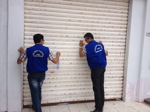 Fiscais da Vigilância Sanitária interditando supermercado em Boa Vista (Foto: Vanessa Lima/G1 RR)